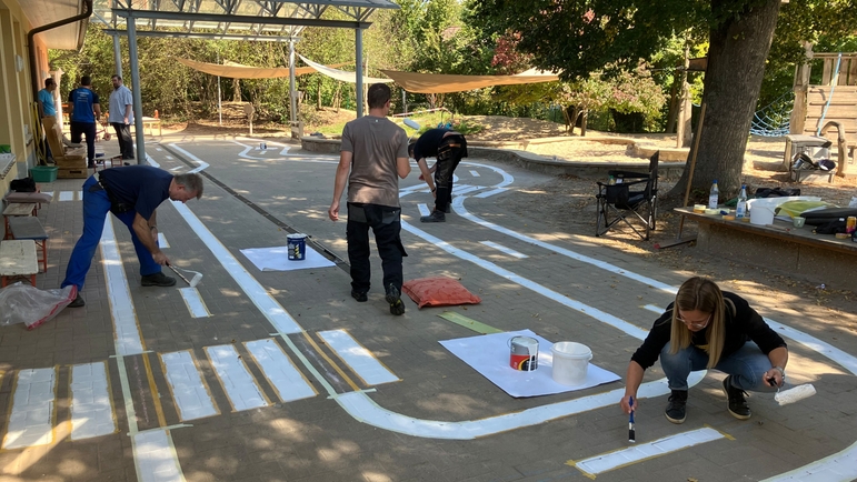 Volunteers work in the garden of a daycare center in Germany.
