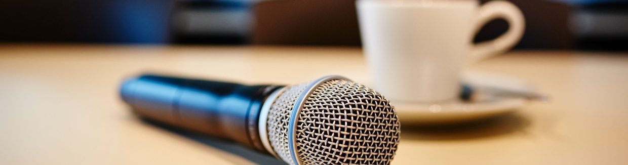 Pressekonferenz Situation: Mikrofon und Kaffeetasse auf einem Tisch.