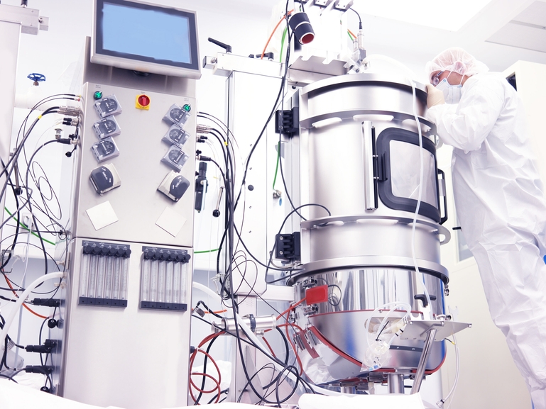 Scientist and a bioreactor in the Life Science industry Scientist working with a bioreactor