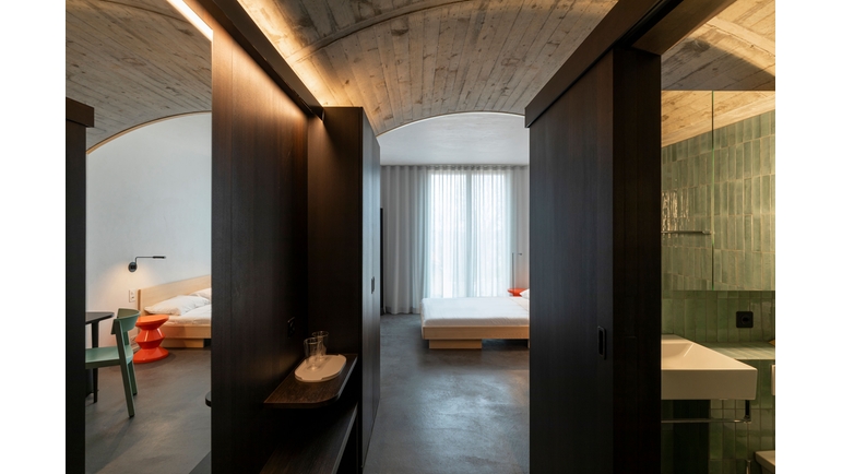 Rooms in the Endress+Hauser guest house incorporate the ceiling of the former indoor swimming pool.